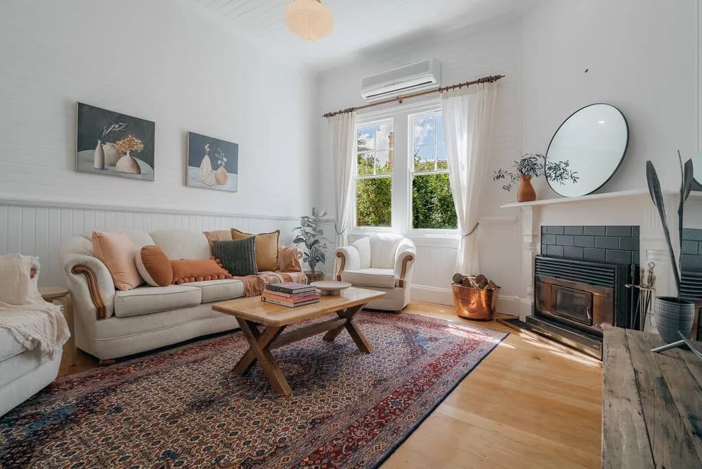 Sunlit living room with fireplace at Quinn’s Cottage